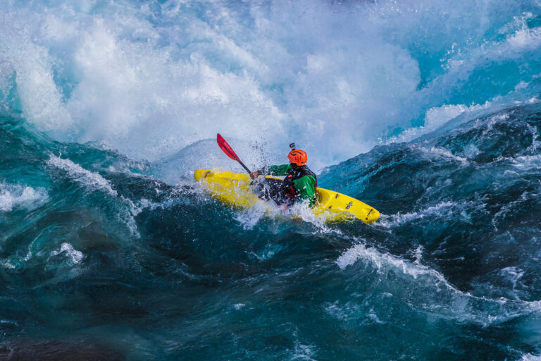 Kayker negotiates the rapids on a turbulent river.