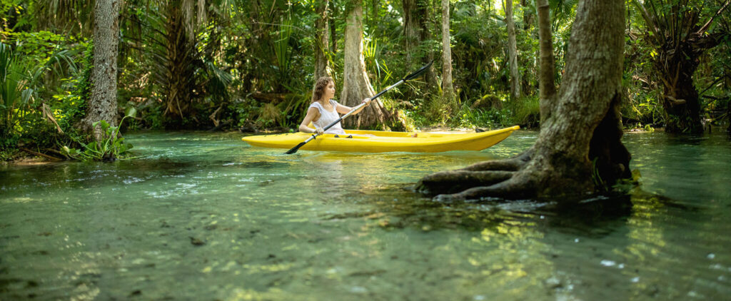 Female kayaker eases through the clear, shallow water of Rock Springs Run.