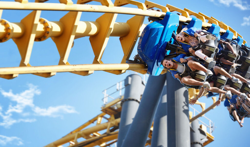 A man and woman scream in joy on a roller coaster ride.