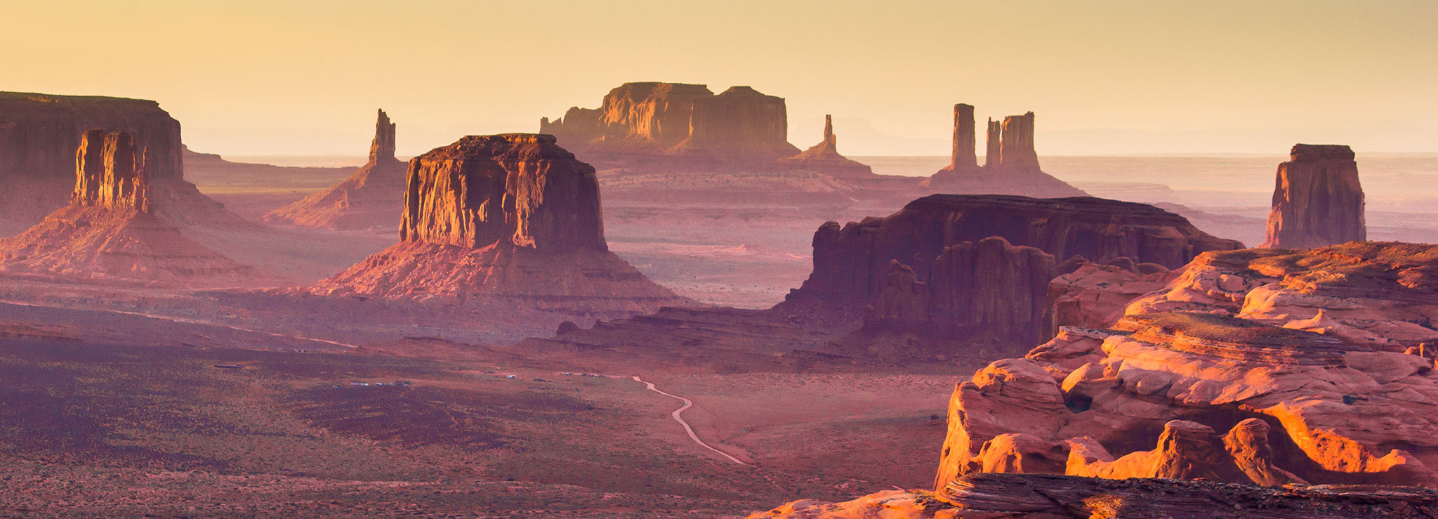 The purple haze of dusk paints vertical rocks formations and mesas.