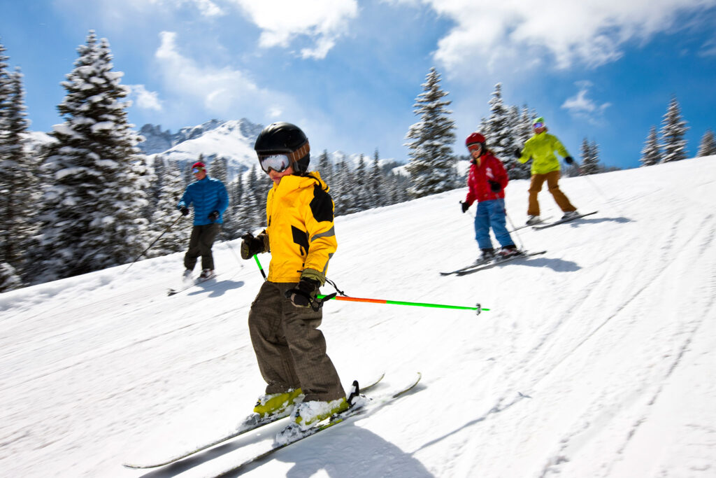 A family swooshes down a mountain.