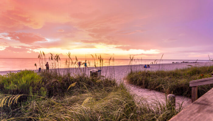 The sun goes down at the Naples beach in the Gulf of Mexico, Southwest Florida, USA. Amazing spot of the sun coming down at blue hour in this idyllic place for family vacation and relax.